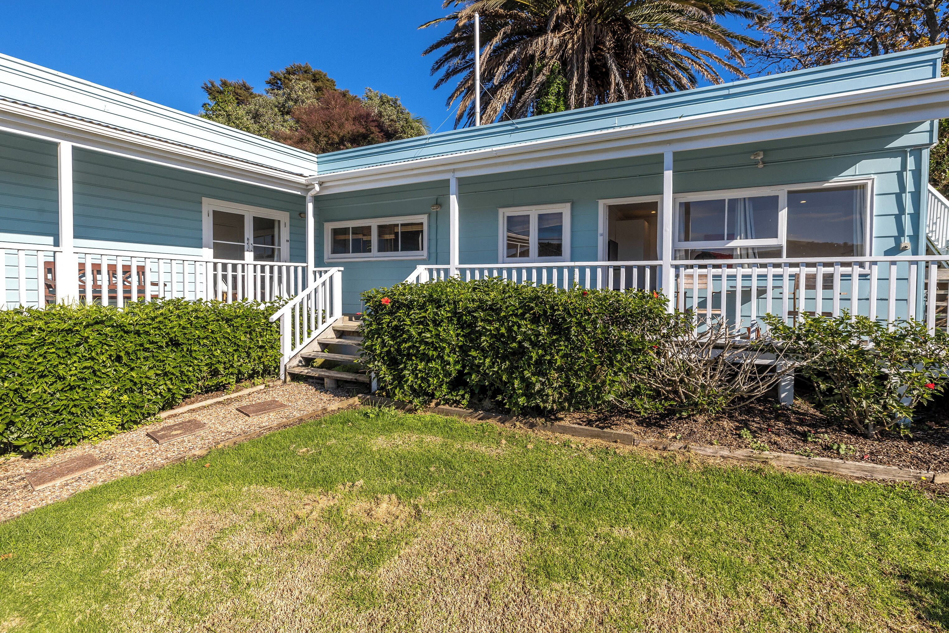 A two-story house with a front porch, a staircase, and a well-maintained lawn.
