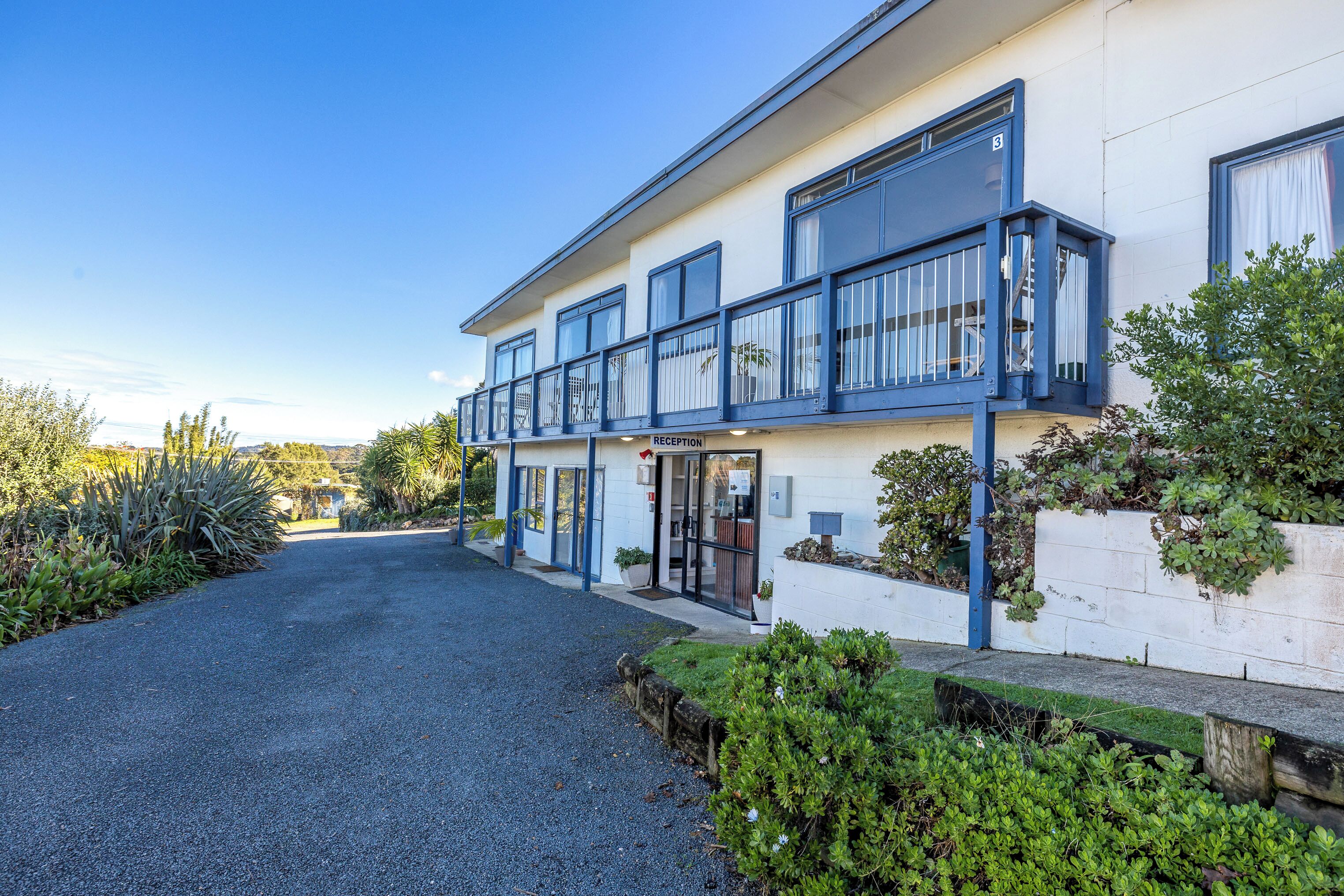 A modern building with a reception area, large windows, and a well-maintained garden.