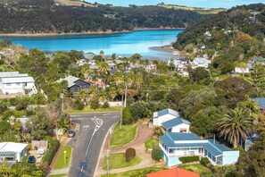 A coastal residential area with houses, a road, and a body of water. - Waiheke Island Motel (Waiheke Island)