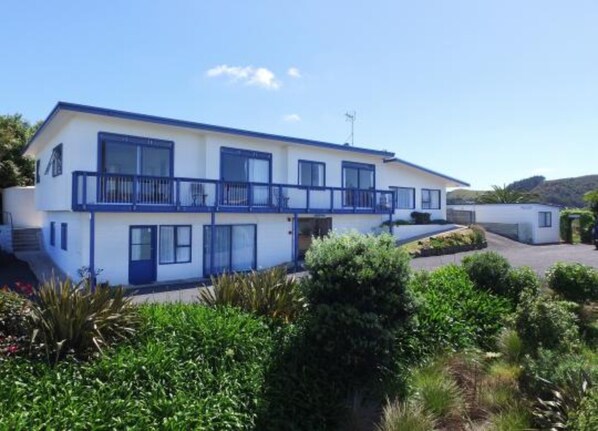 A two-story building with a balcony on the upper floor, surrounded by greenery. - Waiheke Island Motel (Waiheke Island)