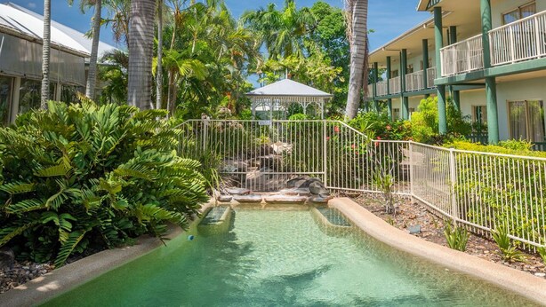 A resort with a pool, palm trees, and a gazebo. - Shamrock Gardens Motel (West Mackay)
