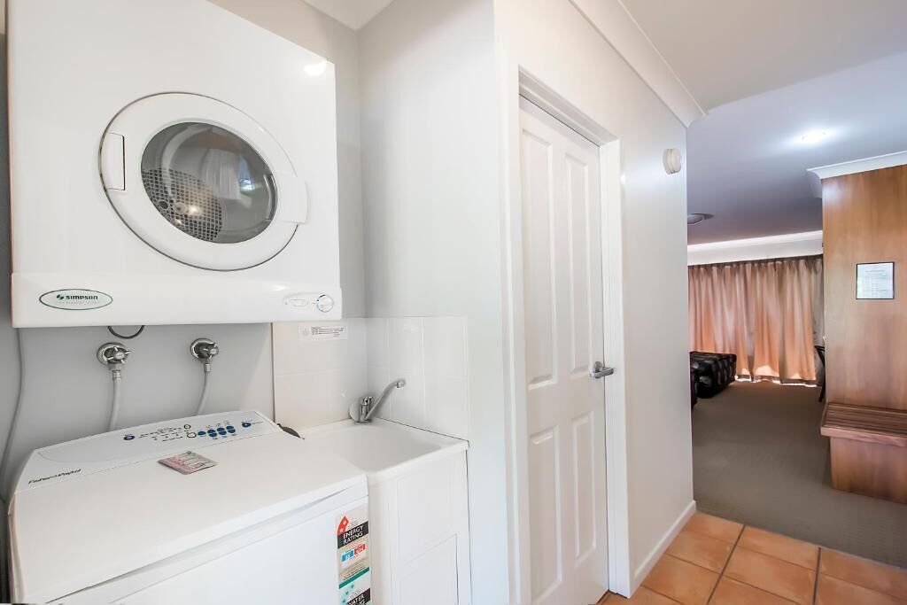 A laundry area with a front-loading washing machine and a top-loading dryer.