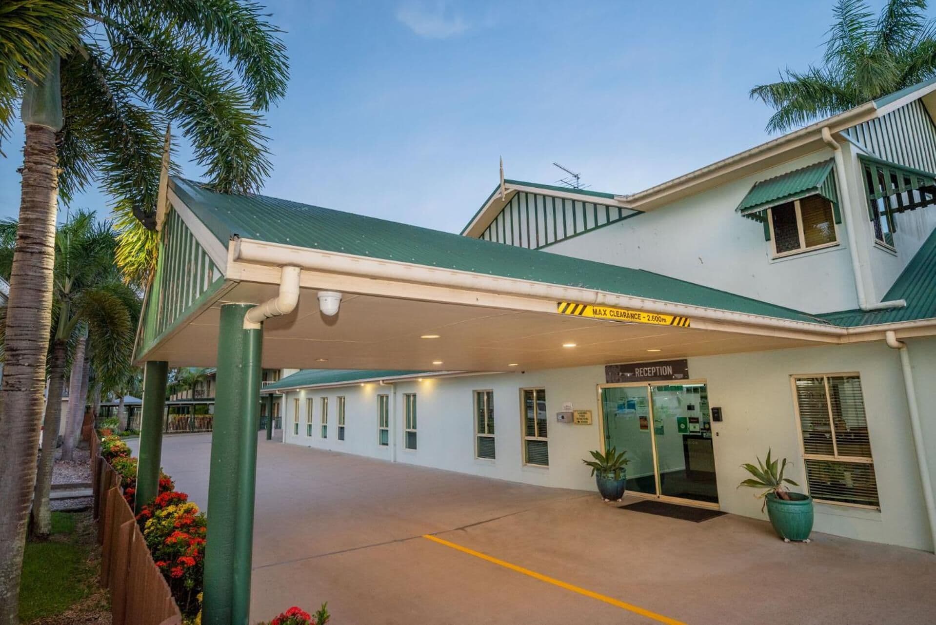 A hotel with a reception area, a covered walkway, and a clear sign indicating a maximum clearance of 2.6 meters.
