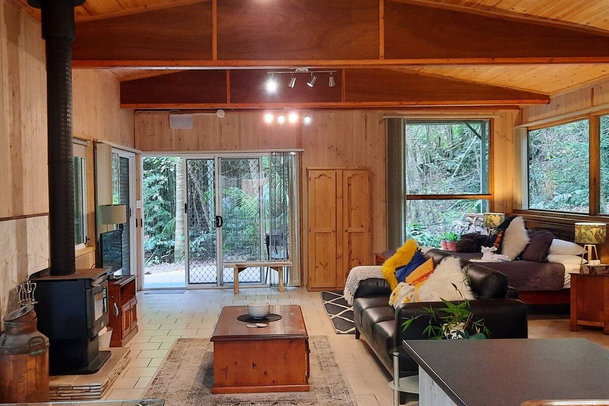 A spacious living room with a fireplace, large windows, and a cozy seating area.
