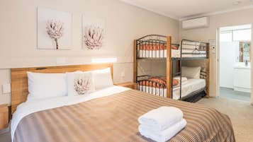 A hotel room with a large bed, bunk beds, and artwork on the walls.