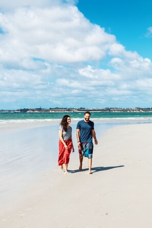 A couple walking on a beach with a clear sky and ocean in the background. - Holiday Lifestyle Henty Bay Portland (Bolwarra)