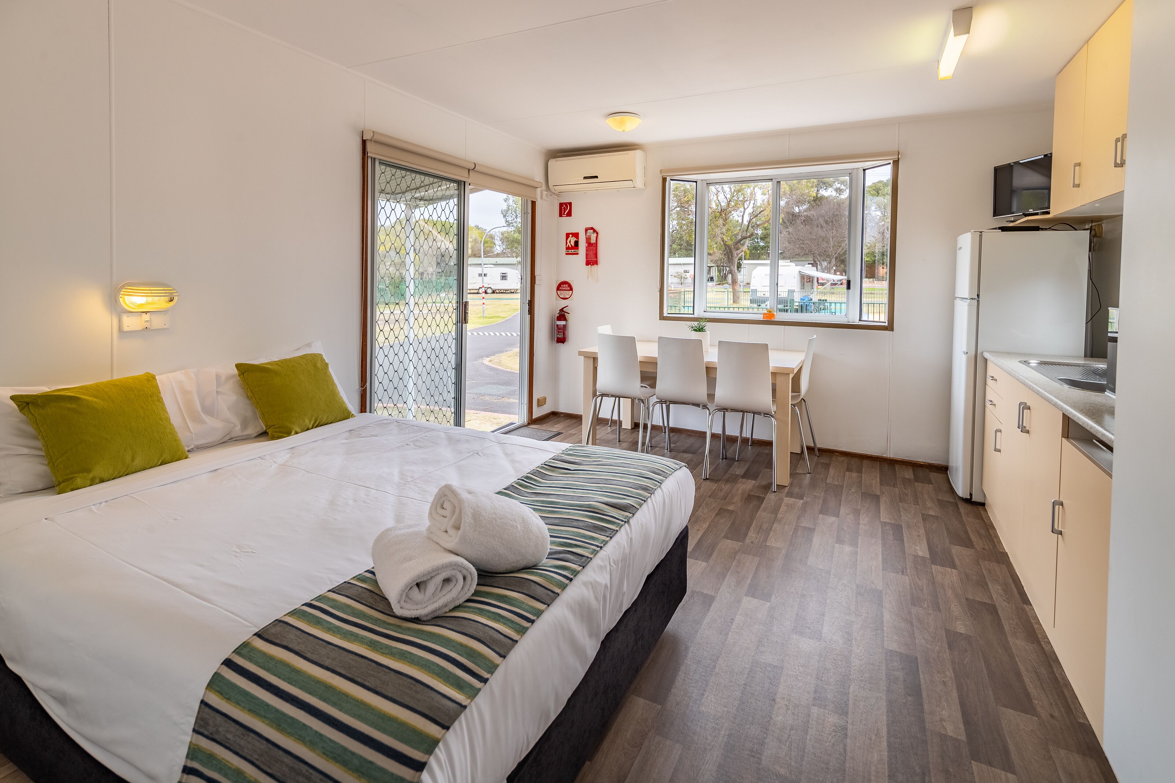 Une chambre d’hôtel avec un lit, un bureau et une kitchenette.
