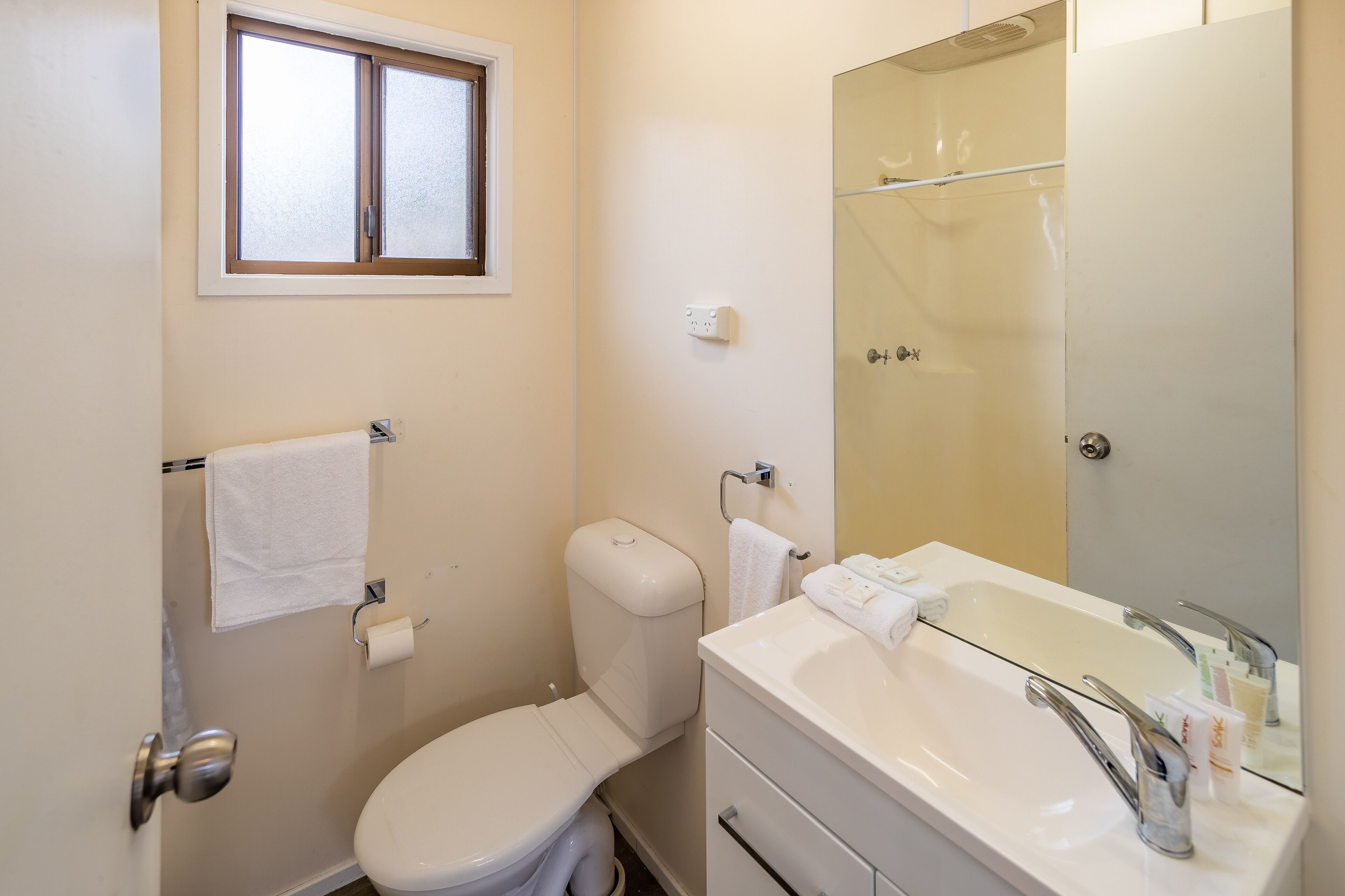 A bathroom with a toilet, sink, and shower.