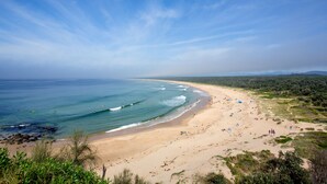 A beach with clear skies, waves, and people. - NRMA Broulee Holiday Park (Broulee)