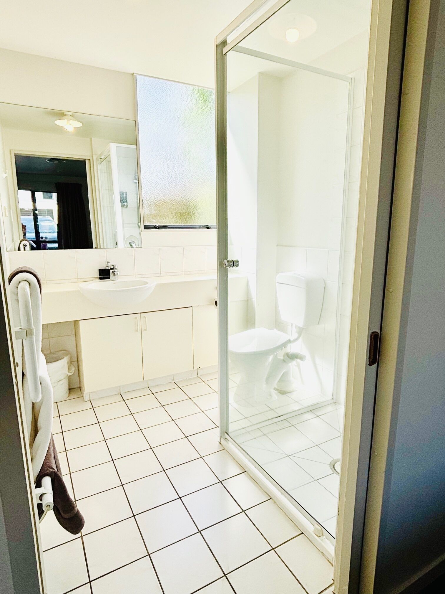 Une salle de bain moderne avec une douche à parois de verre, un lavabo blanc et des toilettes.