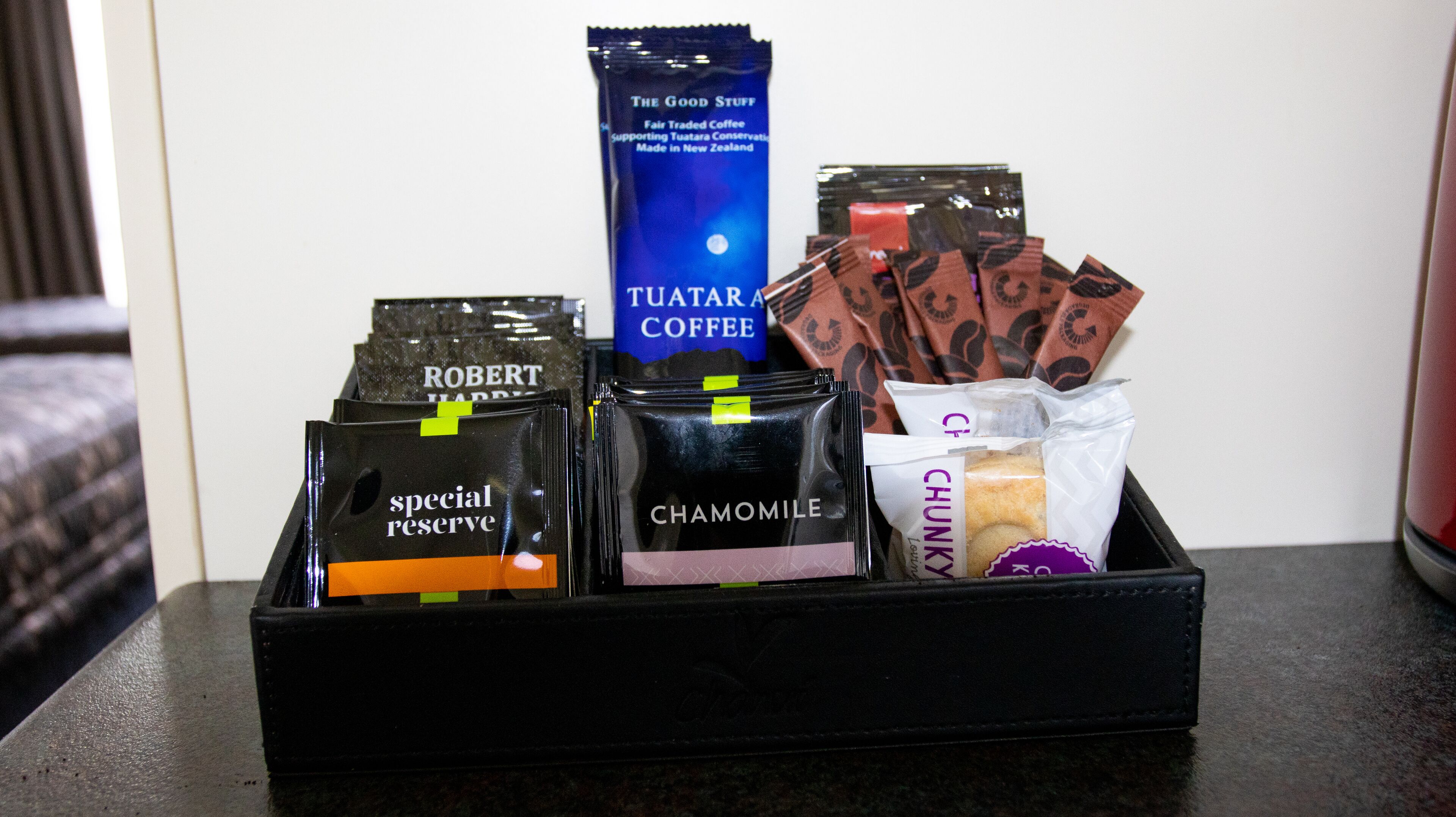 Un plateau contenant divers produits à base de café, notamment les marques « Robert Harris », « Camomille » et « Tuatar Coffee ».