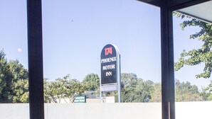 A view of a swimming pool with a sign for the Phoenix Motor Inn in the background.