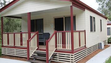 A single-story mobile home with a covered porch and a small front yard.