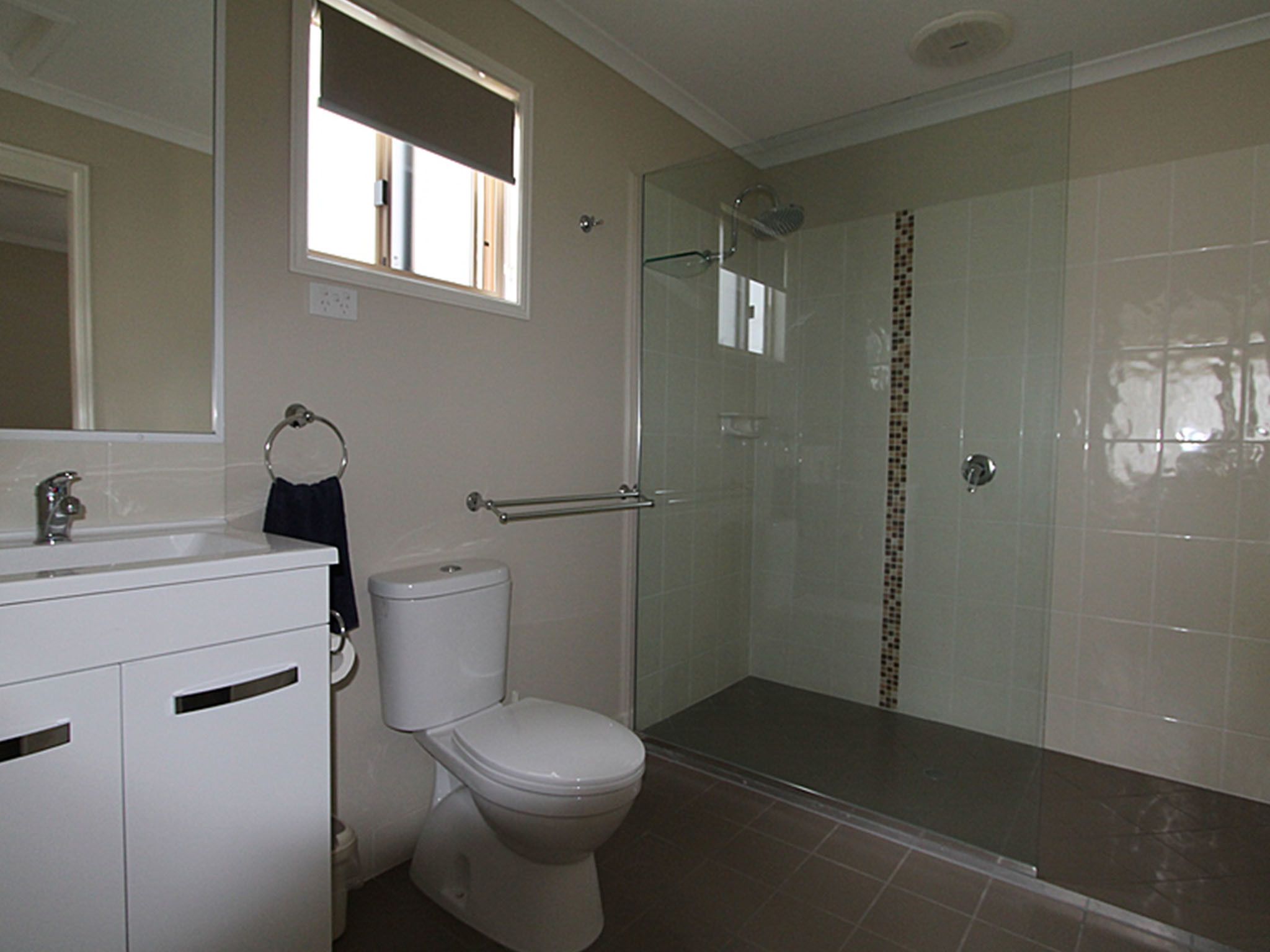 A bathroom with a toilet, sink, and shower.