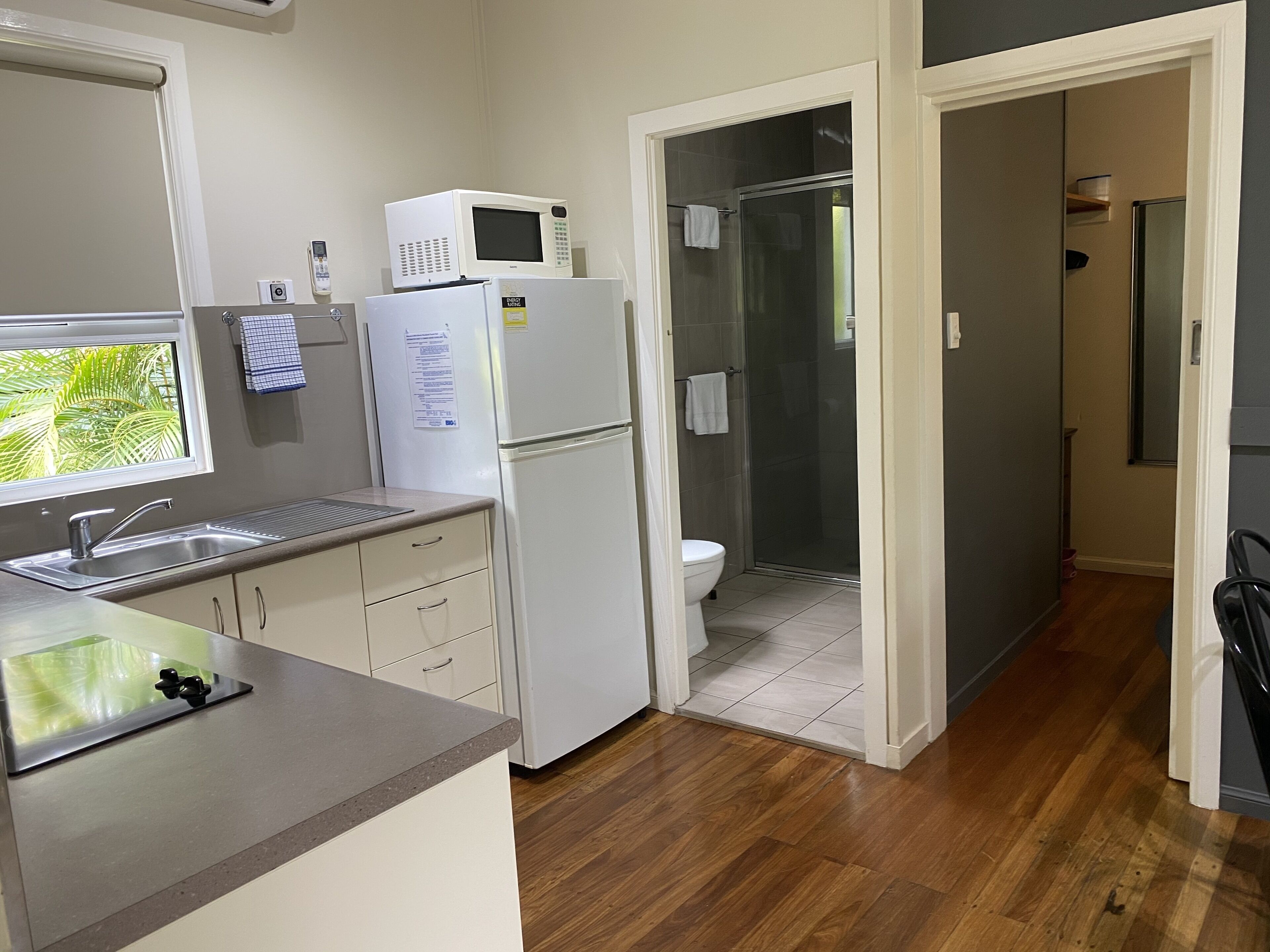 A compact kitchen with a sink, a microwave, and a refrigerator.