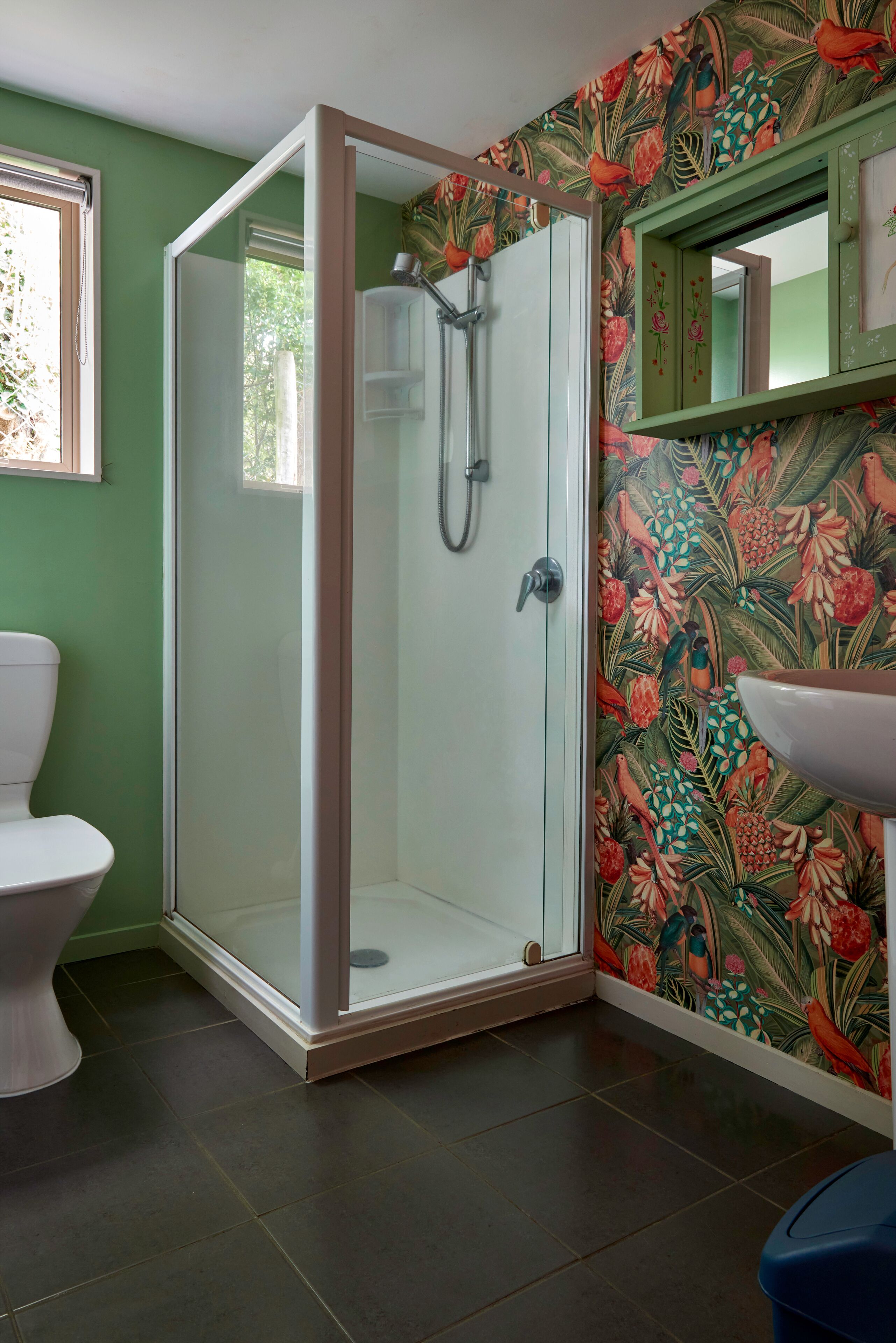 Ein Badezimmer mit Duschkabine, Toilette und Waschbecken.