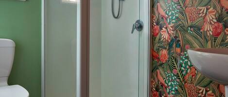 Ein Badezimmer mit Duschkabine, Toilette und Waschbecken.