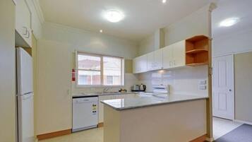 Een koelkast met diepvriezer, een microgolfoven, een oven, een kookplaat