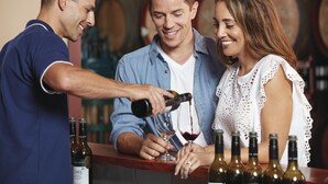 Un bar où un barman verse du vin dans un verre.