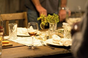 Una mesa de comedor con una copa de vino, un tenedor y un plato con una servilleta.
