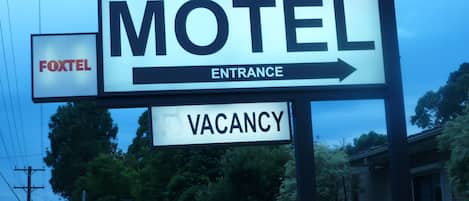 Señal de motel con una clasificación de estrellas y una flecha que indica la entrada.