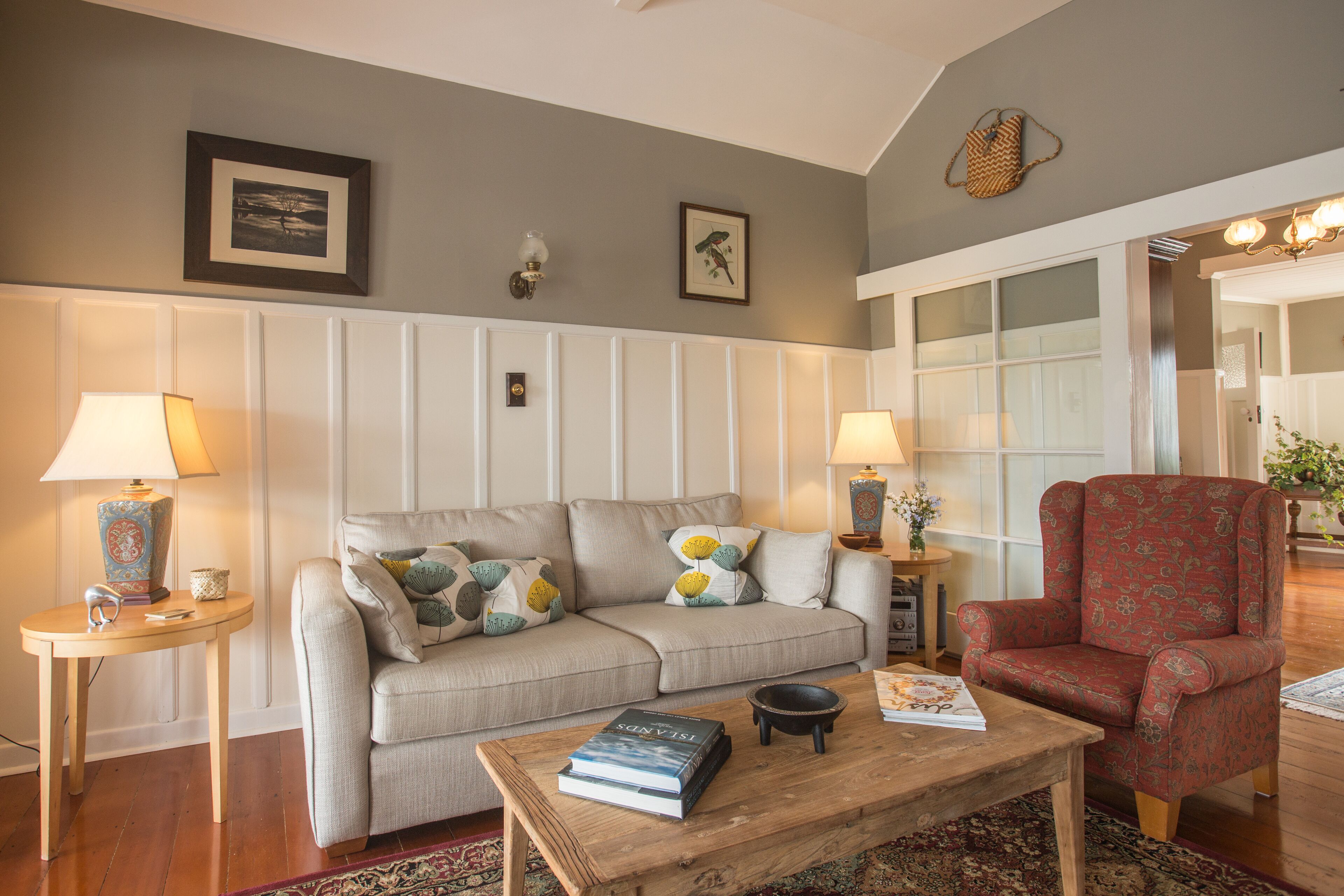 A living room with a sofa, armchair, coffee table, and lamps.