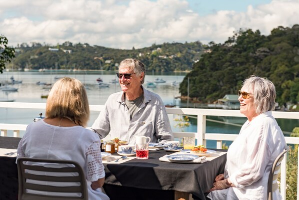A table set for three people with a scenic lake view in the background.