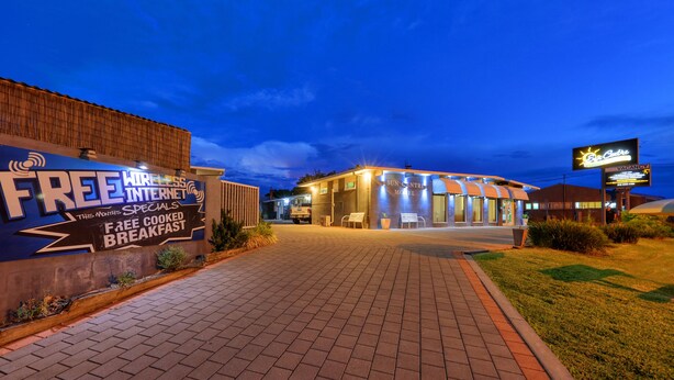 A hotel entrance with a sign offering free wireless internet and a free cooked breakfast. - Sun Centre Motel (Swan Hill)