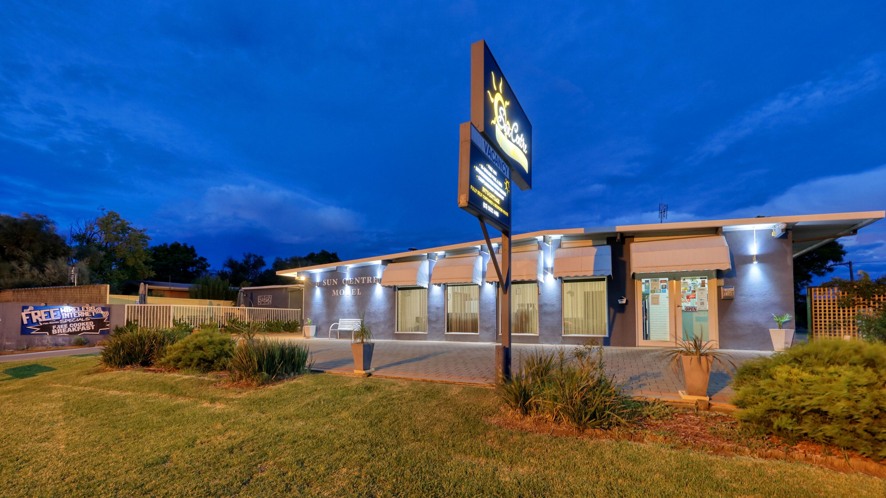 A modern hotel with a sign indicating a vacancy.