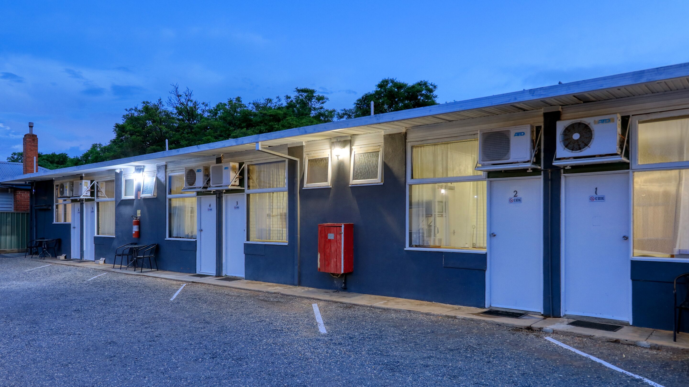 Een motel met individuele kamers genummerd 1 tot en met 4, elk met een eigen ingang.