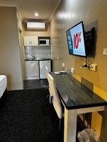 Espacio para trabajar con laptop y tabla de planchar con plancha