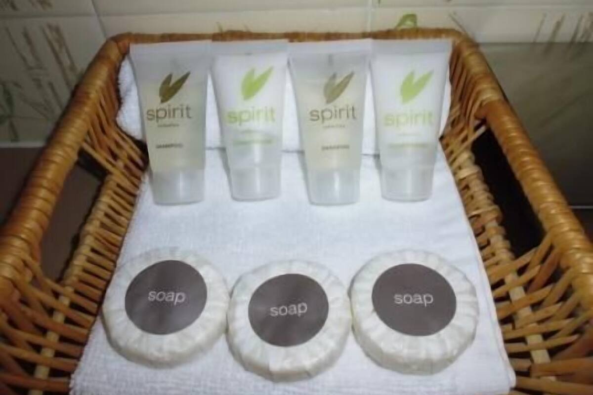 A basket containing four bottles of 'spirit' shampoo and three soap bars.