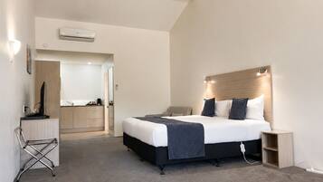 Una habitación de hotel moderna con una cama, una mesita de noche y un escritorio con una silla.