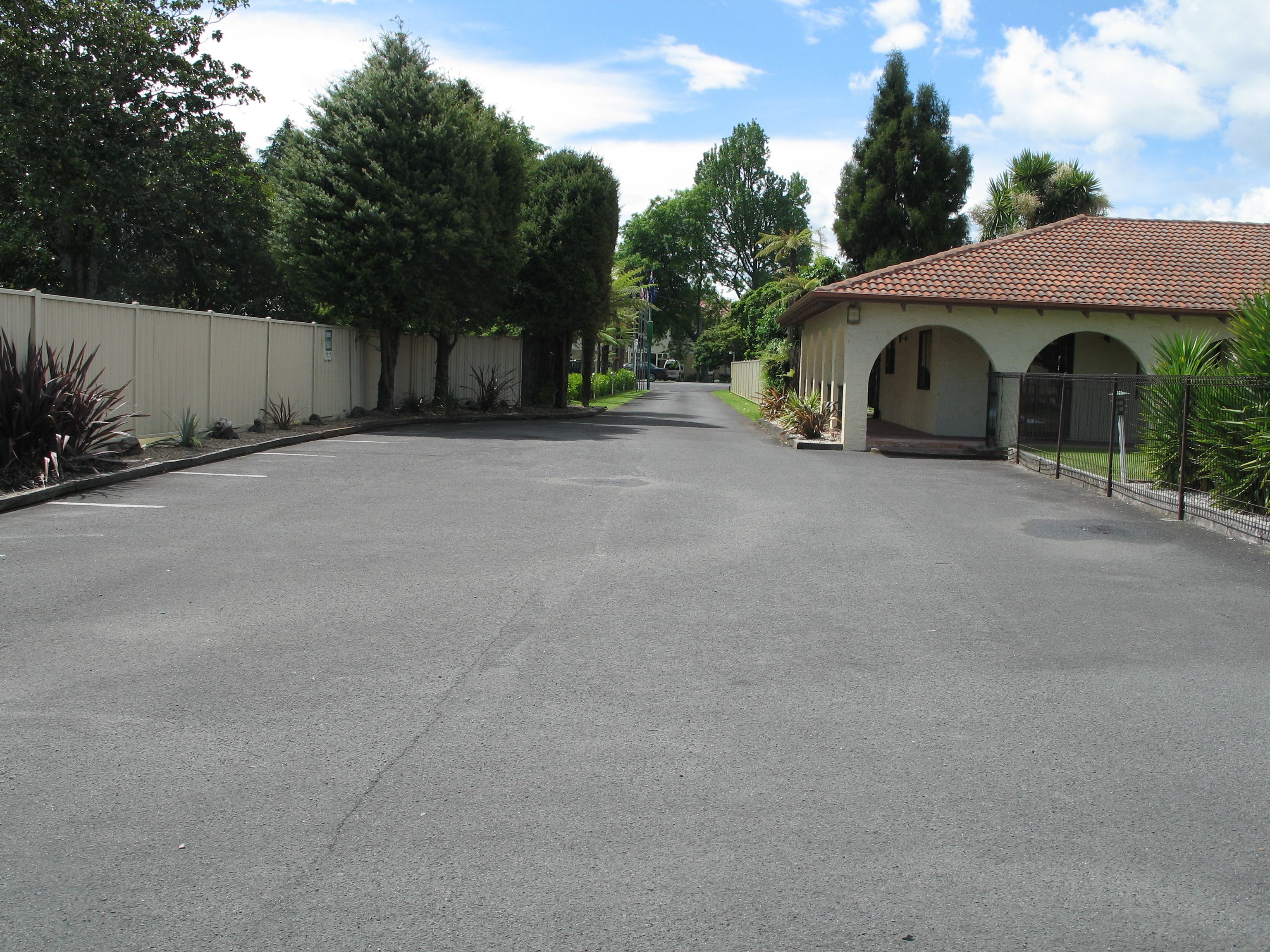 Una calle tranquila con un edificio de techo de tejas y entrada arqueada.