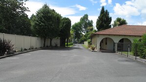 A quiet street with a building featuring a tiled roof and arched entrance. - Captains Quarters Motor Inn (Cambridge)