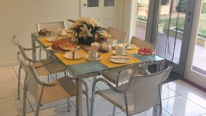 A dining area with a table set for four, including plates, cups, and a croissant. - Sabina On Little Myers (Geelong)