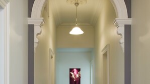 A hallway with a marble floor, white trim, and a decorative ceiling light. - Sabina On Little Myers (Geelong)