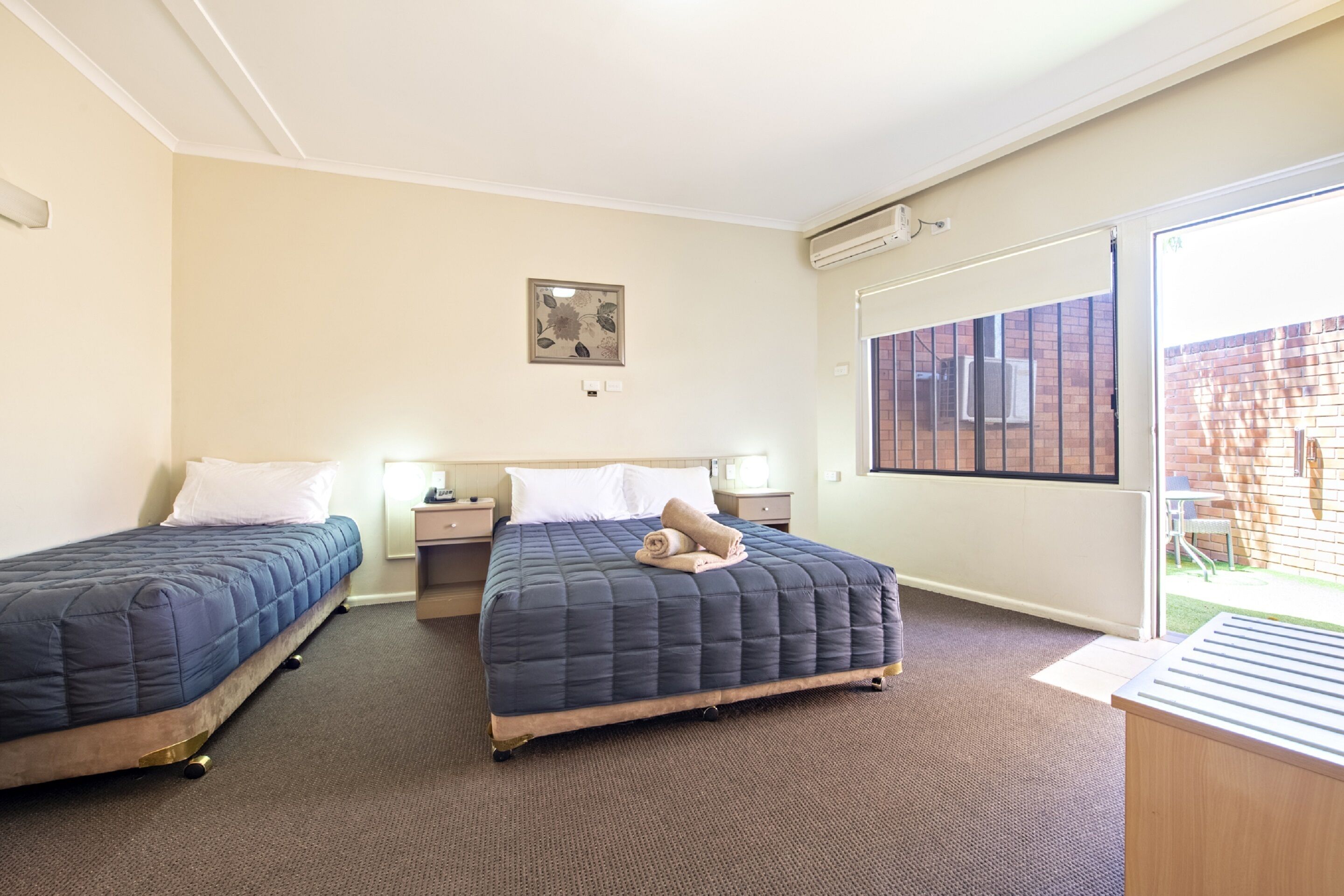 Ein Hotelzimmer mit zwei Betten, einem großen Fenster und Blick nach außen.