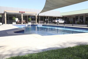 A swimming pool with a reception area and a covered seating area. - Matilda Motor Inn (Dubbo)