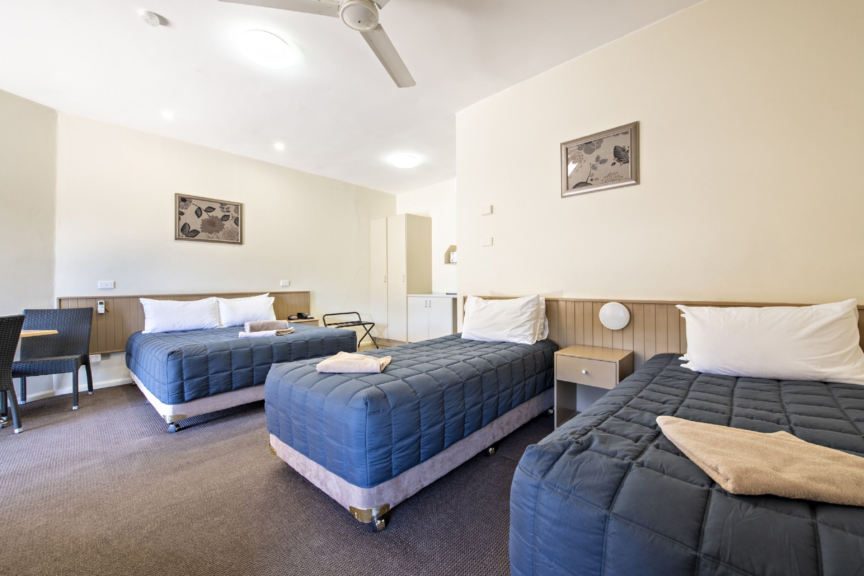 Une chambre d’hôtel avec deux lits, un bureau et une chaise.