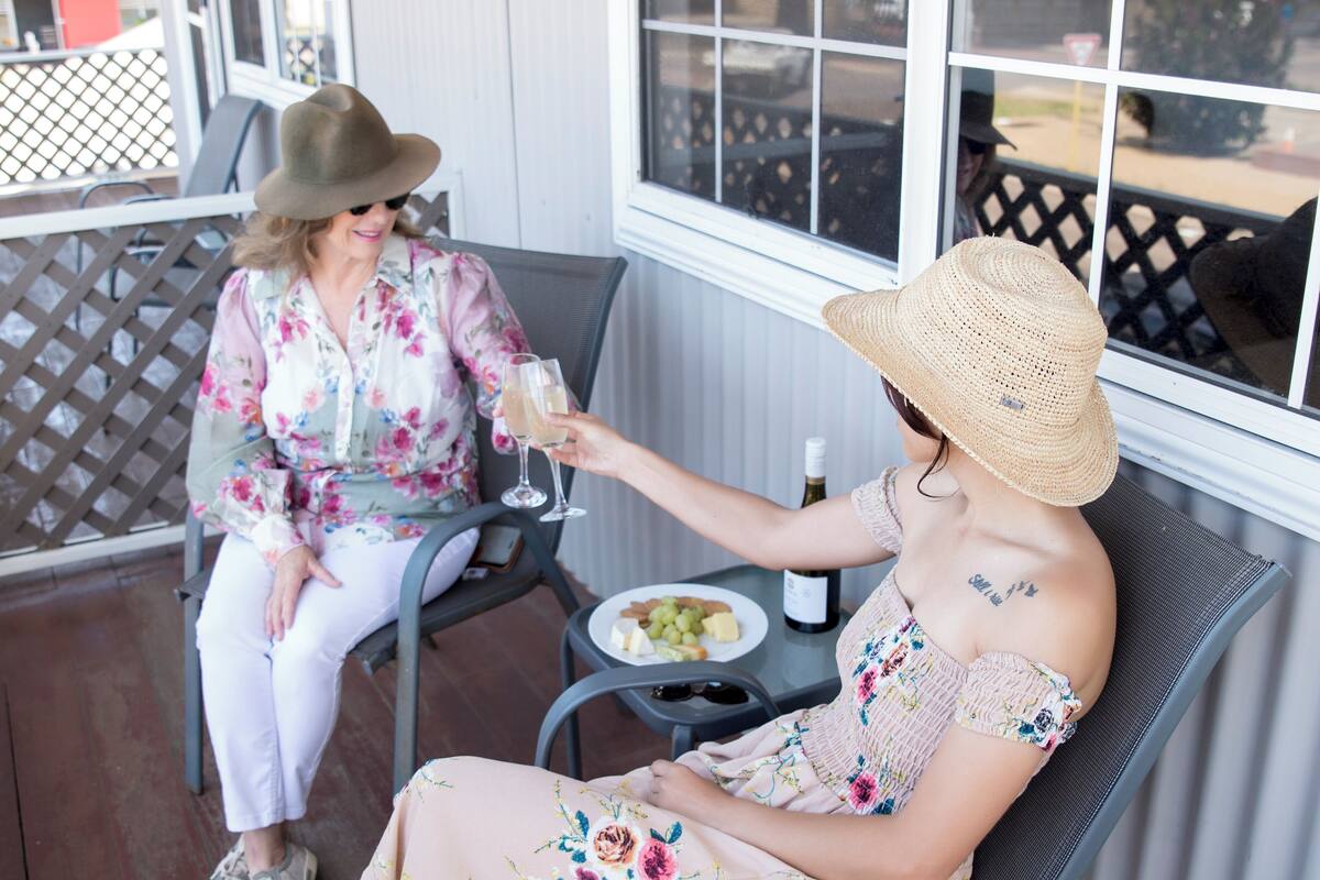 Two people seated at a table with a bottle of wine and a plate of food.