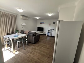 Apartamento superior, 1 cama de matrimonio grande | Zona de estar | Televisión de pantalla plana de 110 cm con canales digitales