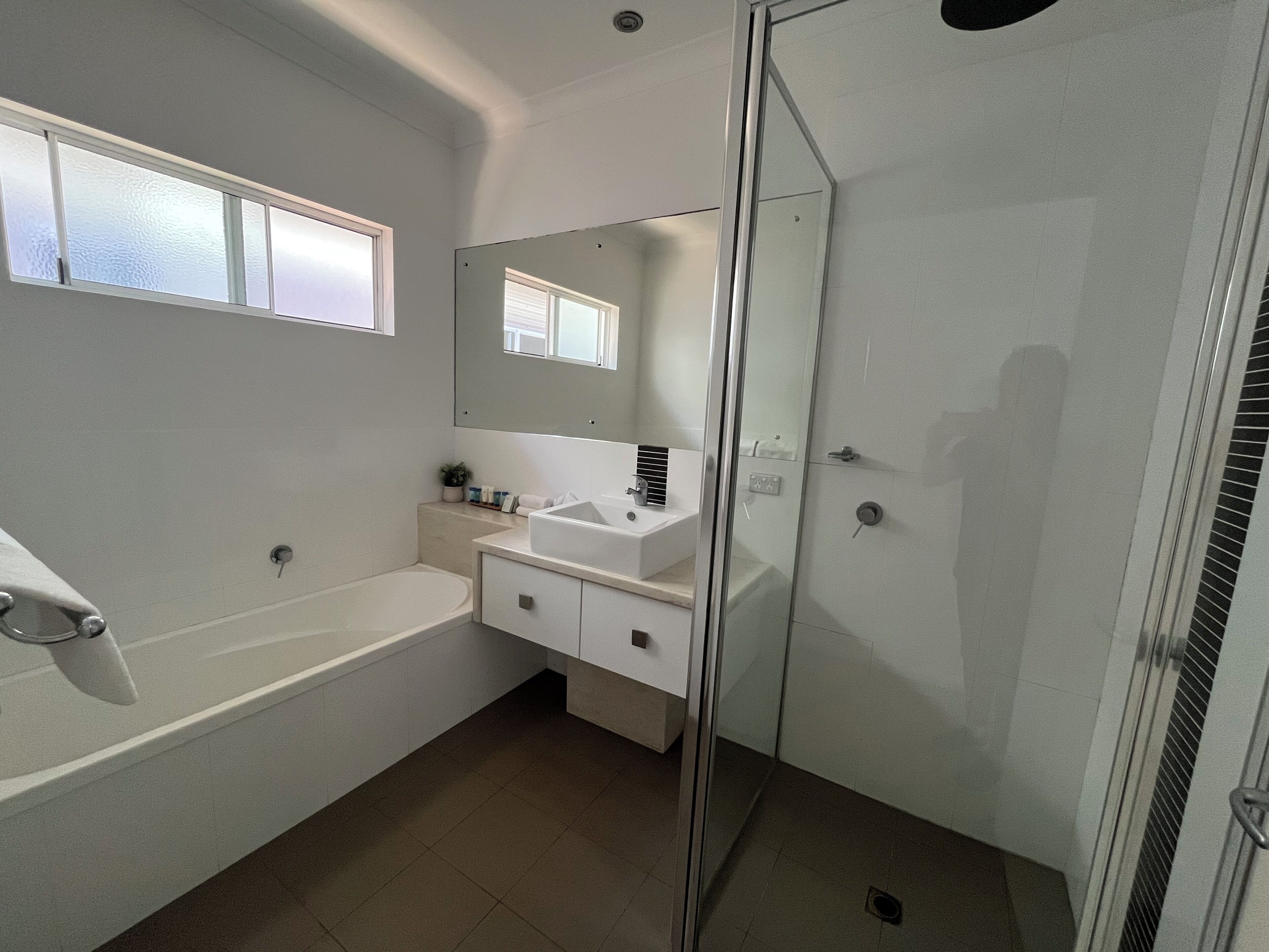 A modern bathroom with a bathtub, a sink, and a glass-enclosed shower.