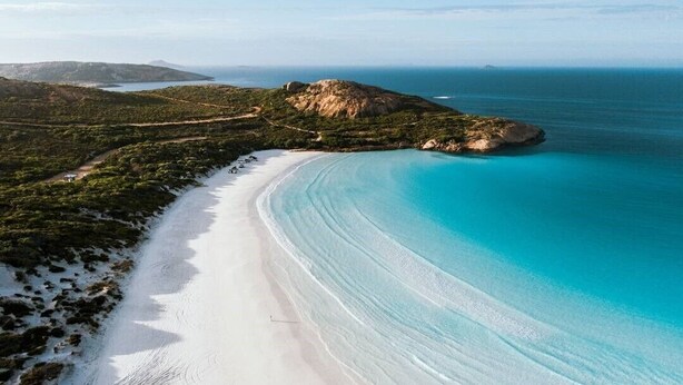 A coastal landscape with a sandy beach, clear turquoise waters, and a mountainous backdrop. - Clearwater Motel Apartments (Esperance)