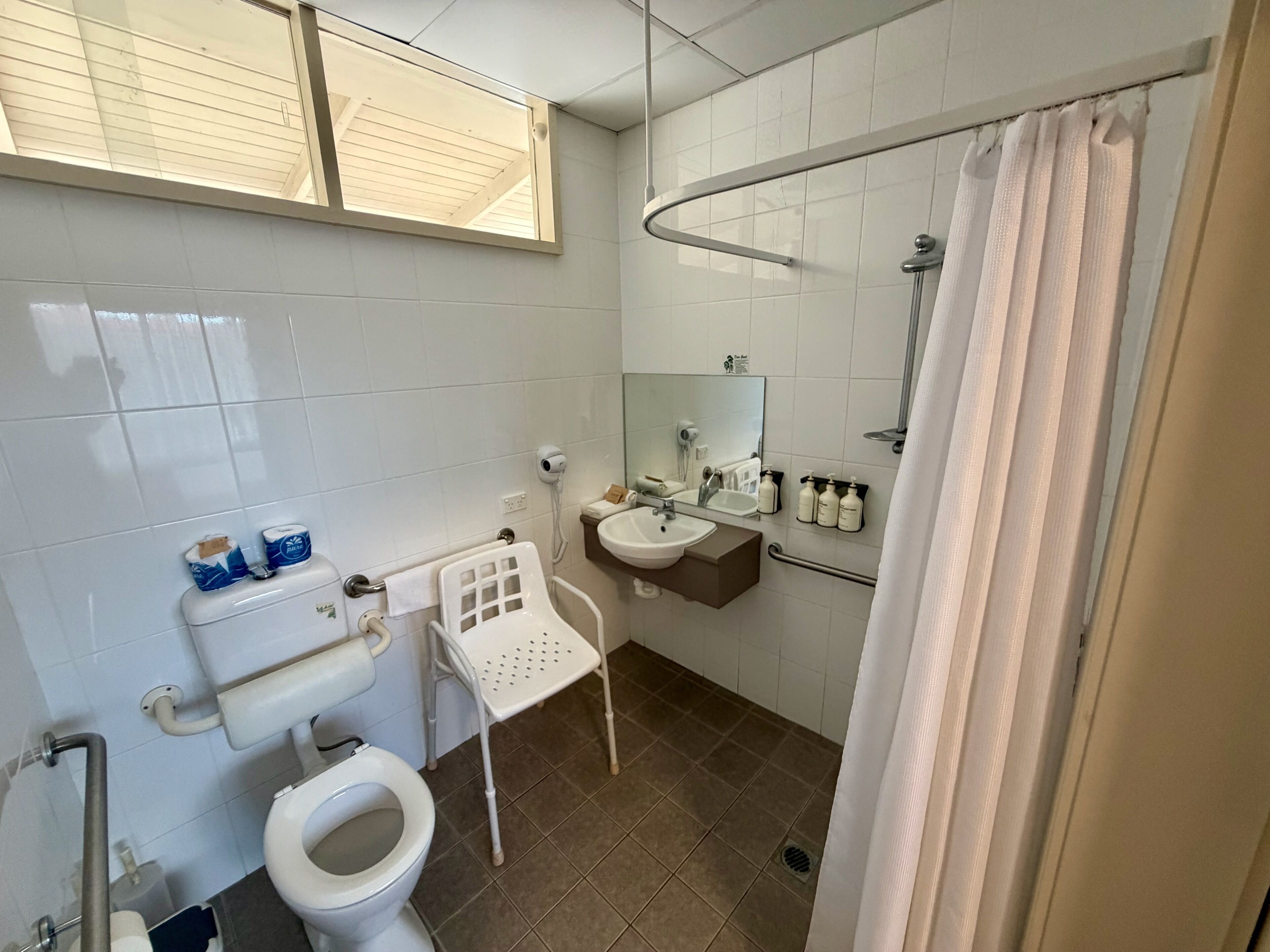 Bagno con toilette, lavabo, specchio e zona doccia.