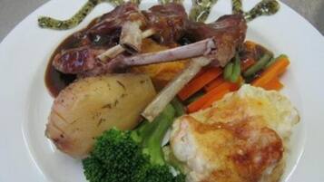 A plate with roasted meat, vegetables, and mashed potatoes.