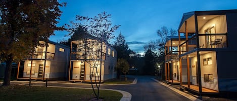 A modern residential building with a central courtyard, large windows, and a well-lit entrance.