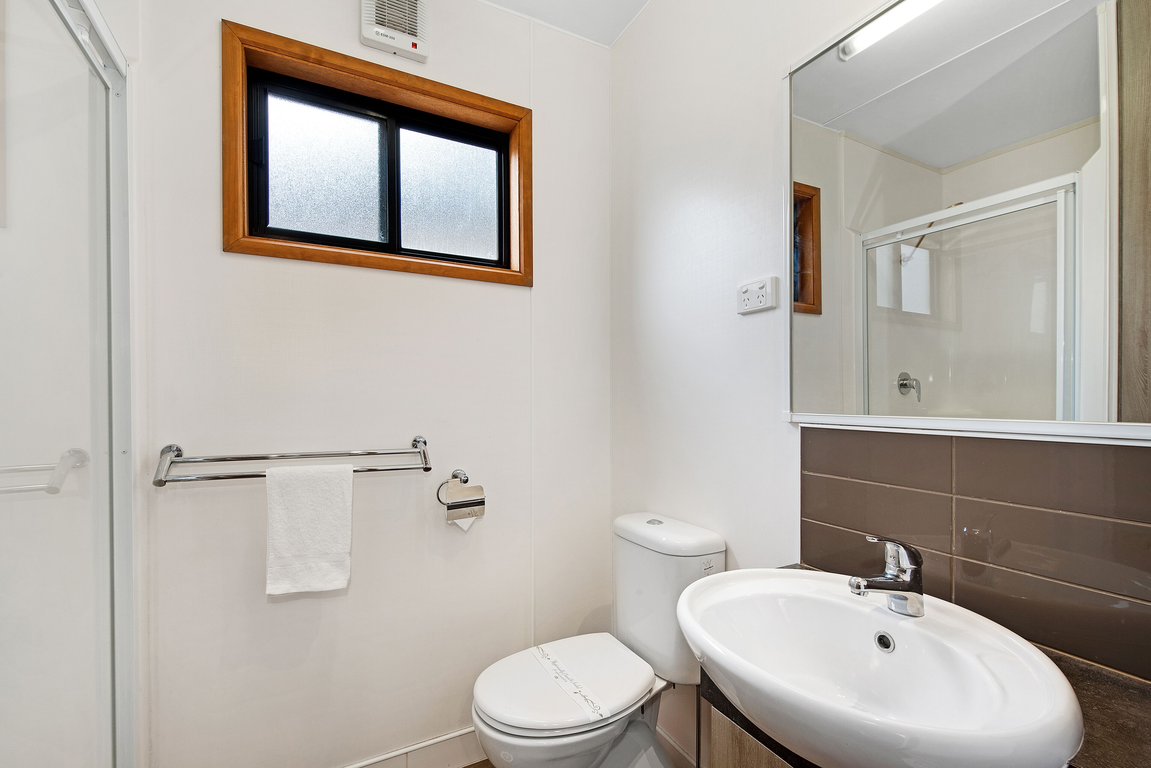 Un baño con inodoro, lavamanos y ventana.