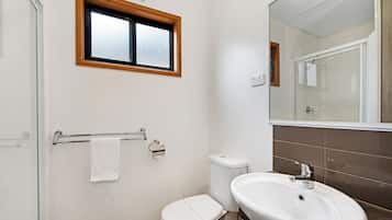 Un baño con inodoro, lavamanos y ventana.