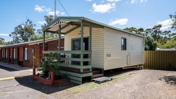 A mobile home with a porch and a small garden area.